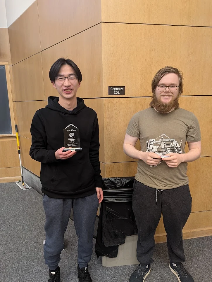 Two competition participants displaying their awards