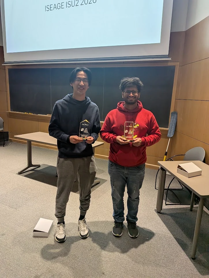 Two competition participants holding first-place awards